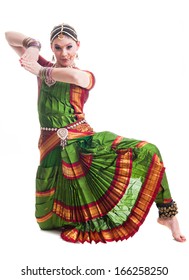 Bollywood dancer in green and orange folded dress posing as cobra