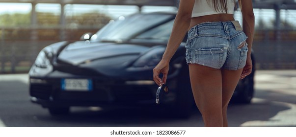 BOLOGNA, ITALY - AUGUST, 2020: Woman Holding Key Of Porsche 718 Cayman Parked In The Street. Porsche Is A German Automobile Manufacturer Specializing In High-performance Sports Cars Founded In 1931.