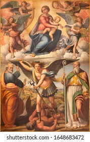 BOLOGNA, ITALY - FEBRUARY 3, 2020: The painting of Madonna with archangel Michael and the saints in church San Michele in Bosco by Innocenzo da Imola (1490 –1550).