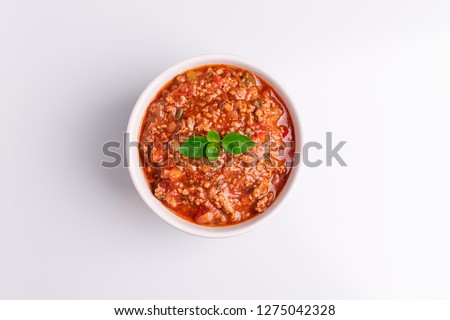 Bolognese (also know as Bolognesa or Bolonhesa) sauce in a white bowl isolated in white background, soft light, studio photo, top view, copy space