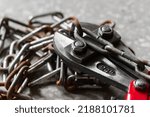 Bolt cutters rebar shears and iron chain background.