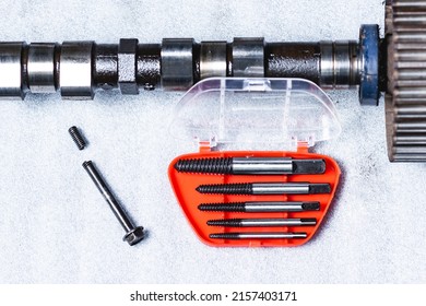 Bolt extractor, broken bolt, screw, stud extractor. Against the background of a disassembled camshaft of an internal combustion engine
