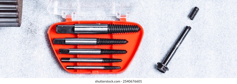 Bolt extractor, broken bolt, screw, stud extractor. Against the background of a disassembled camshaft of an internal combustion engine