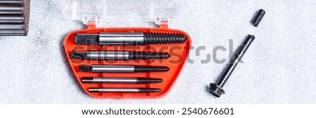 Bolt extractor, broken bolt, screw, stud extractor. Against the background of a disassembled camshaft of an internal combustion engine