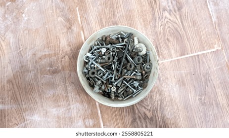 A bolt, nut or concrete nail that is in a bucket container.  - Powered by Shutterstock