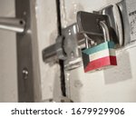 A bolted door secured by a padlock with the national flag of Kuwait on it.(series)