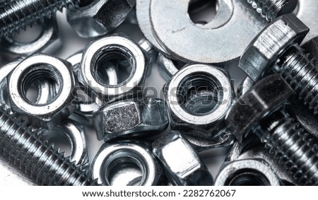 Bolts, nuts and washers in close-up scattered on a white background. Background with metal elements.