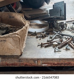 bolts and screws and all sorts of old junk on a dusty wooden table in the garage. copy space.