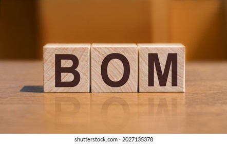 BOM - Bill Of Materials, Text On Wooden Cubes On Orange Wall Background.