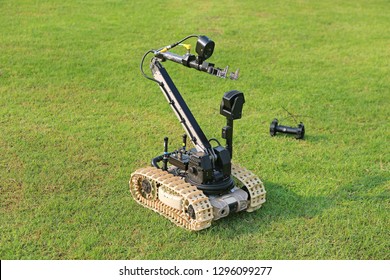 Bomb detection and disposal robot on green grass field.