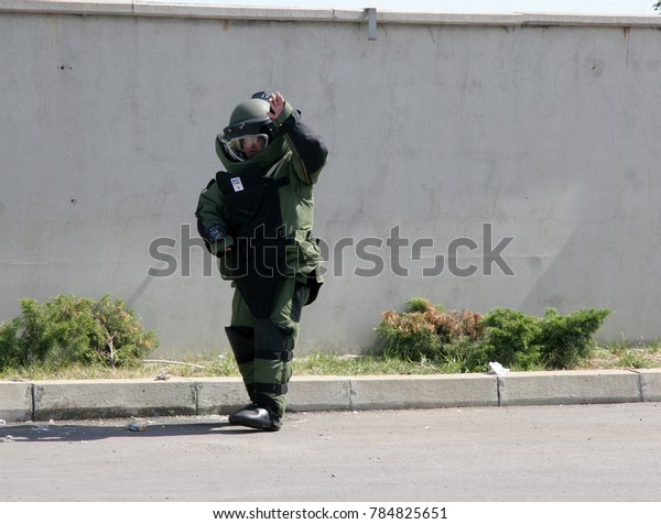 A bomb disposal agent\
in a bomb suit disarm a bomb inside a car of terrorists during\
military training in the city of Sofia, Bulgaria on Sep,11, 2007.\
Bomb squad robot