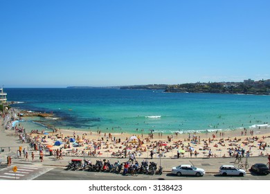 Bondi Beach In Sydney, Australia, Showing Green Waters, Blue Sky, Lots Of People On A Wonderful Sunny Day