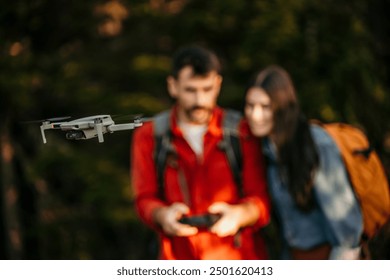 Bonding couple exploring the nature and using a drone to take a photos and videos