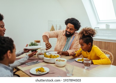 Bonding over lunch time. Afro family of four having lunch together at home - Powered by Shutterstock