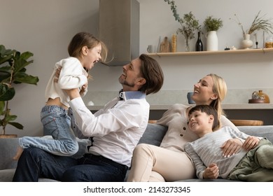 Bonding Relaxed Happy Young Mother And Small Son Watching Joyful Father Lifting In Air Laughing 6s Preschool Kid Daughter, Cheerful Multigenerational Family Having Fun Together On Weekend At Home.