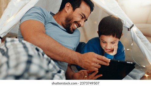 Bonding, tablet and father in a tent with kid watching a movie, video or show online. Happy, smile and young dad networking on social media with boy kid on digital technology in blanket fort at home. - Powered by Shutterstock