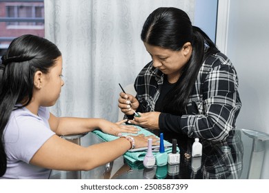 Bonding time: mother and daughter share a home manicure moment. A single mother lovingly cares for her daughter's hands, painting and grooming her nails. The scene reflects the tenderness - Powered by Shutterstock