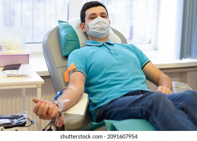 Bone Marrow Donation. Man In Medical Mask, Male Hand Holding Red Ball, Blood Transfusion System, Blood Bag. Soft Focus