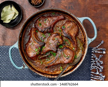 Bone In Pork Chops In Pot With Spoon On Wooden Table With Spices