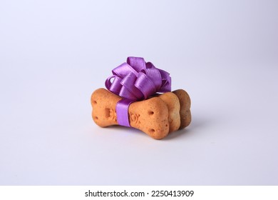 Bone shaped dog cookies with purple bow on white background - Shutterstock ID 2250413909