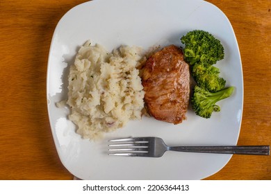 Boneless Barbecue Pork Chop Served With Broccoli And Red Mash Potatoes