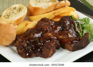 Boneless Beef Ribs In Barbecue Sauce With Fries And Garlic Bread