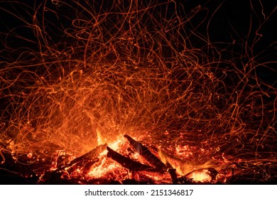 Bonfire shot at night at long exposure with randomly flying sparks