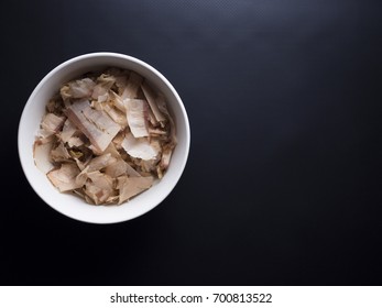 Bonito flakes made from dried, smoked and thinly shaved skipjack tuna flakes. Isolated on black background