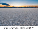 Bonneville Salt Flats low angle blue yellow colorful landscape twilight sunset near Salt Lake City, Utah and silhouette view of mountains and sun setting behind clouds