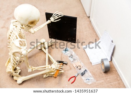 Bony skeleton assembling a black wooden shelf