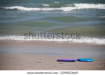 boogie board body board left abandoned on the beach object nobody copy space in front of ocean seaside