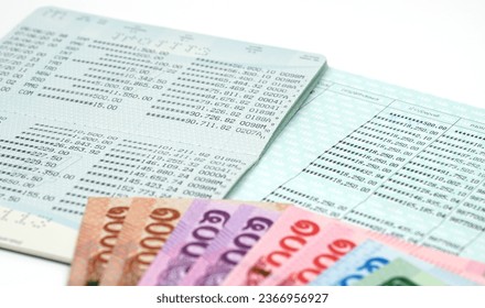 Book bank saving  with banknotes,bank account passbook . Bookbank statement and thai currency. Financial bookkeeping, Accountancy , Transactions concept and idea of saving money, investment,bank loan - Shutterstock ID 2366956927
