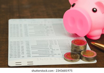 Book bank saving  with thai currency coins, pen, Pink piggy bank account passbook . Bookbank statement.. Financial bookkeeping, Accountancy , Idea of saving money, investment on white background.