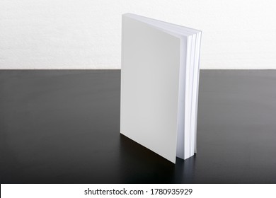 Book with blank cover on black background, editable mock up template ready for your design, selection path included.