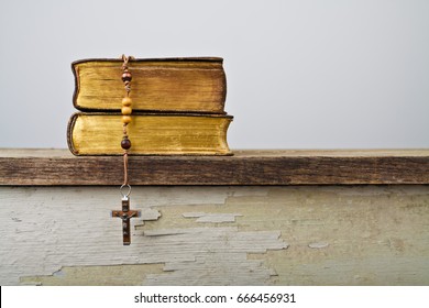 The Book Of Catholic Church Liturgy And Rosary Beads On The Wooden Table