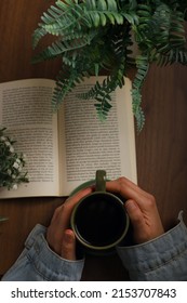 Book And Coffee On Wooden Background. Novel And Coffee Pleasure In Greenery. The Perfect Combination Of Book And Coffee