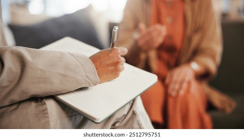 Book, counseling and hand of therapist writing notes for client with mental health evaluation. Paper, medical information and psychiatrist with patient for psychology assessment or review in office. - Powered by Shutterstock