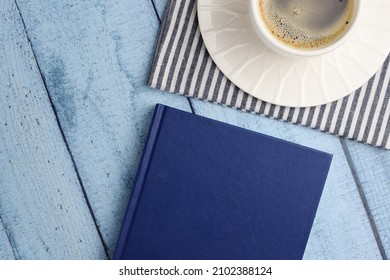 Book And Cup With Coffee On A Wooden Table. Top View, Flat Lay. Rest And Relaxation Concept.