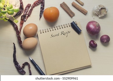 Book With Egg, Onion And Spices On Wooden. Word Secret Recipe