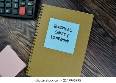 The Book Of Electrical Safety Handbook Isolated On Wooden Table.