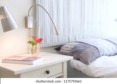 A Book And Flowers On A Nightstand Table In The Bedroom On A Sunny Morning