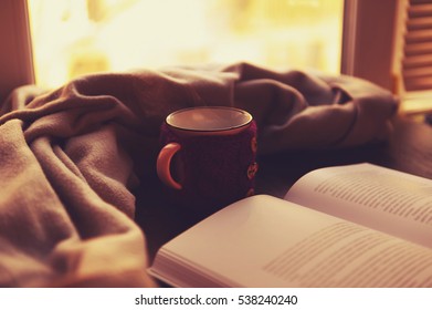 Book Hot Tea And A Warm Blanket At Sunset. The Concept Of Comfort. Read Bestseller. Warm Home.