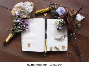 Book of incantations, grimoire, dried flowers, thistle, wand of feathers, quartzite crystal and candles made from natural wax, witchcraft, spells, magic, wicca, center for text, goddess