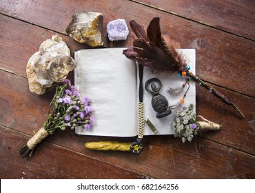 Book of incantations, grimoire, dried flowers, thistle, wand of feathers, quartzite crystal and candles made from natural wax, witchcraft, spells, magic, wicca, center for text, goddess