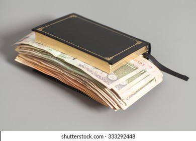 Book with Indian Currency Rupee bank notes on gray background