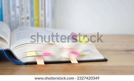 Book instruction manual reference sticky paper note blur background.