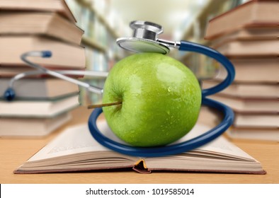 Book In Library With Apple And Stethoscope