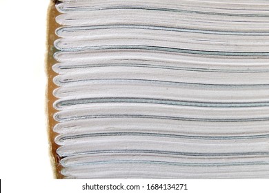 A book lying horizontal showing the type of book binding where pages of the book are folded into section and attached together onto the cover using a strong glue. Closeup macro view.