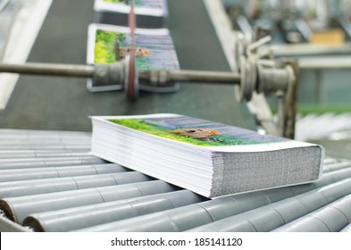 Book, magazine,  production line into press plant house. Automatic assembly line close up