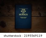 The Book of Mormon: Another Testament of Jesus Christ on wooden background.